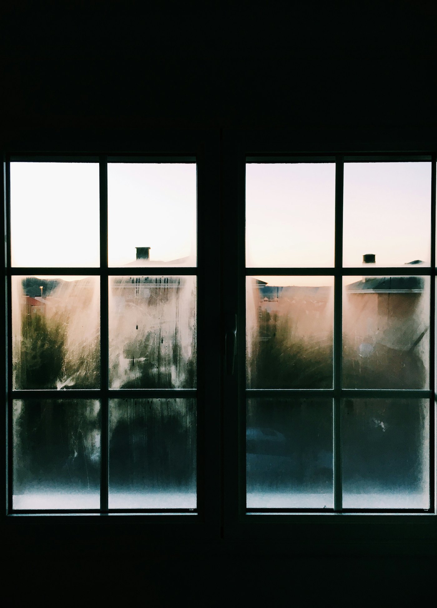 Condensation on a closed bedroom window at dawn
